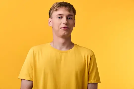 Молодой блондин в жёлтой футболке на жёлтом фоне