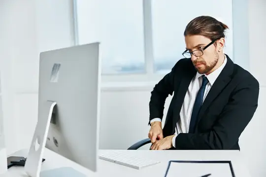 Офисный работник возле рабочего стола с офисным компьютером