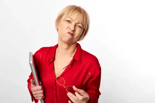 Недовольная блондинка в красной рубашке с папкой и очками