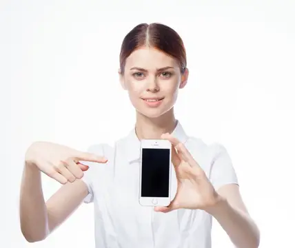 Молодая женщина в белом халате показывает на смартфон