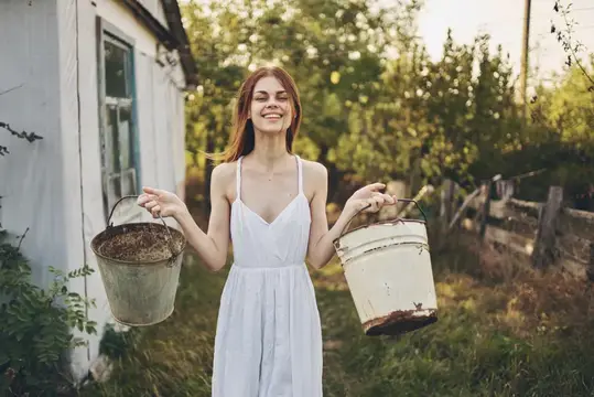 Красивая женщина работает в деревне на природе, ведя здоровый образ жизни