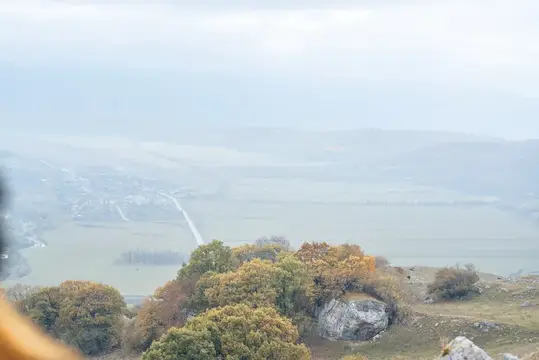 Туманный вид на долину с осенними деревьями и скалами с высоты