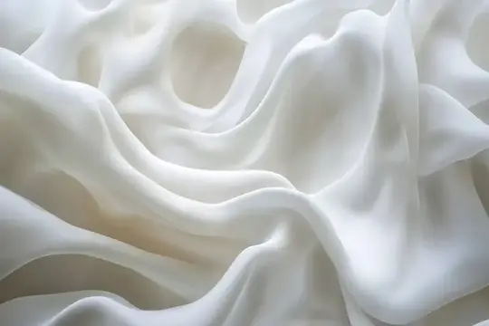 Белые складки мягкой ткани крупным планом