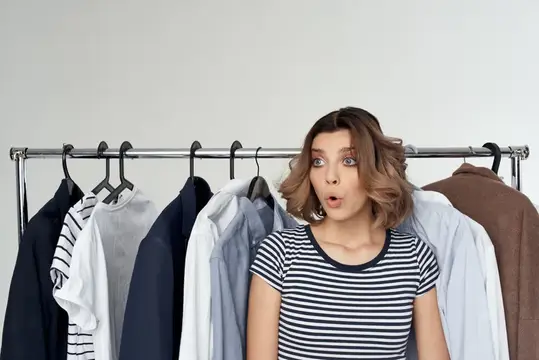 Симпатичная женщина рядом с одеждой, мода, веселье, изолированный фон