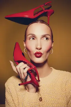 Девушка с красными туфлями на голове и в руке