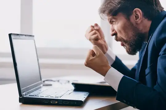 Менеджер сидит за столом перед ноутбуком, работая в финансовой сети