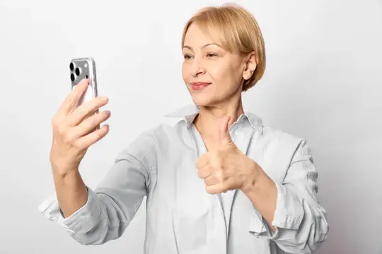 Женщина делает селфи на смартфон в студии