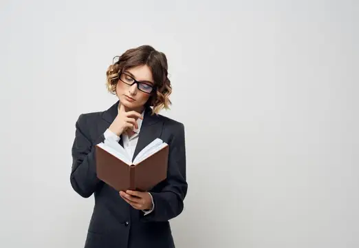 Деловая женщина с книгой в руках на светлом фоне