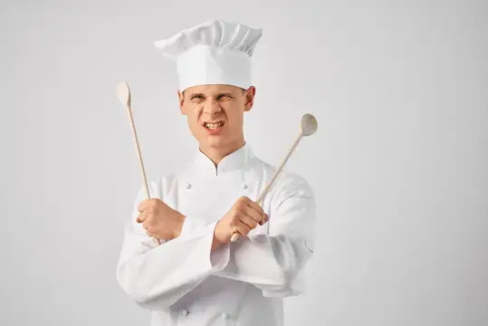 Шеф-повар-мужчина в форме с кухонными принадлежностями, профессиональная работа, персонал