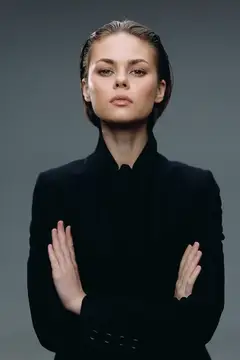Строгая женщина в черном костюме со скрещенными руками