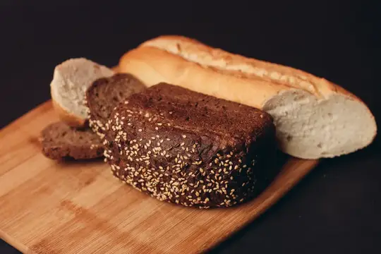 Ржаной хлеб с кунжутом и багет на деревянной доске