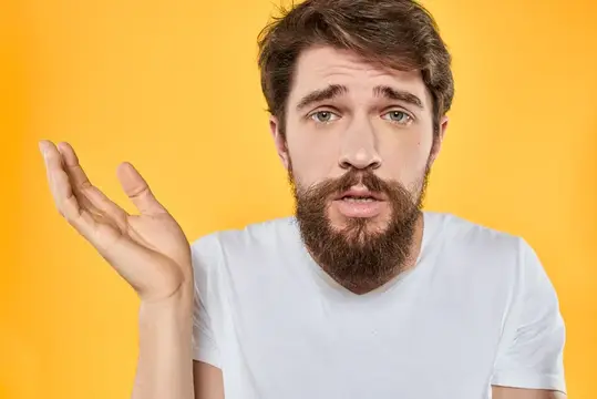 Мужчина в белой футболке жестикулирует руками