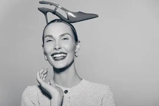Улыбающаяся женщина с туфлей на голове