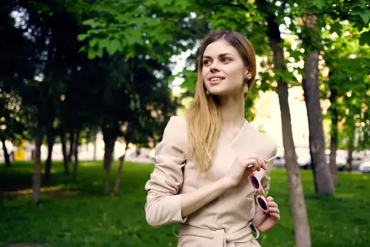 Симпатичная женщина в солнцезащитных очках и шляпе в парке, зеленая трава, модель