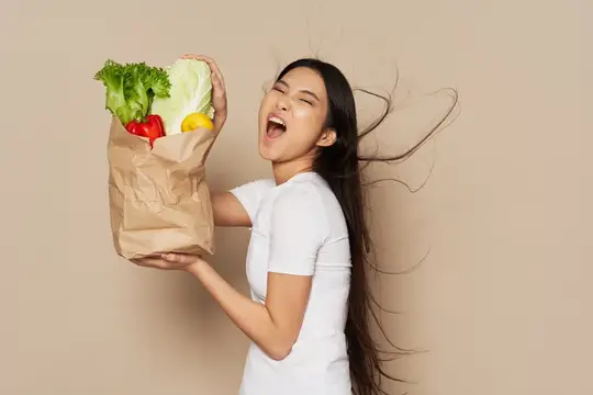 Женщина в белой футболке держит пакет с продуктами