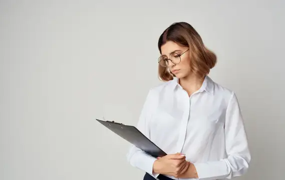 Молодая женщина в очках с планшетом в руках