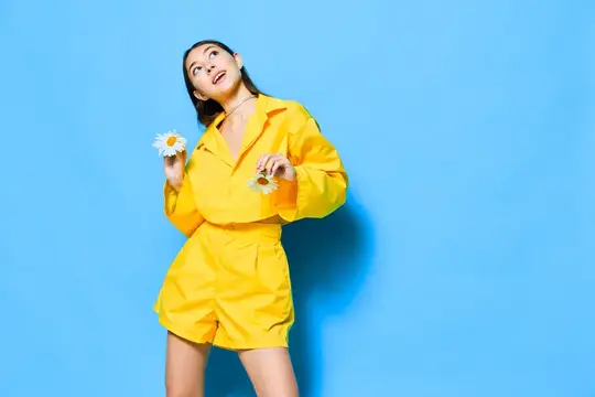 Молодая женщина в жёлтом костюме с ромашками на голубом фоне