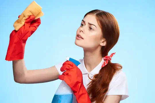 Профессиональная уборщица выполняет работу по дому на синем фоне