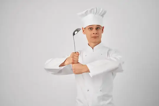 Мужчина профессионально готовит, держа кастрюлю