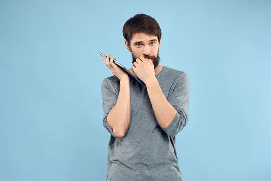 Задумчивый бородатый мужчина с блокнотом на голубом фоне
