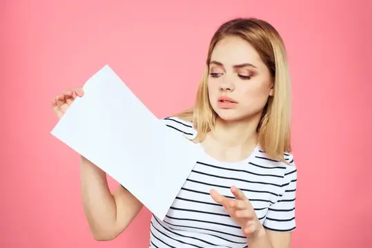 Женщина держит в руках белый лист