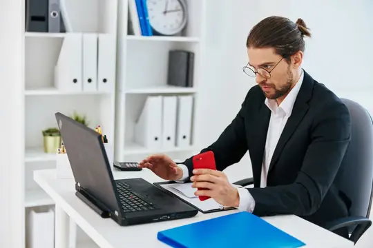 Мужчина в костюме с телефоном и ноутбуком, работа, эмоции, образ жизни