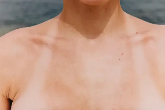 Загорелые плечи и шея мужчины на фоне моря