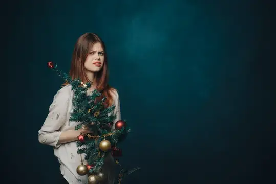 Девушка с ветками ели и ёлочными шарами на тёмно-зелёном фоне