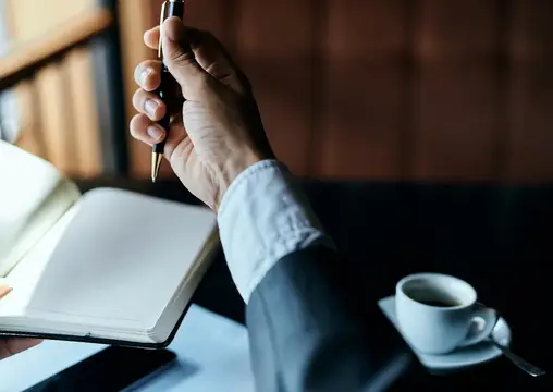 Бизнесвумен в кафе с книгой на столе, документами и чашкой кофе, работа, образ жизни