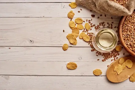 Хлопья, зерно и масло на светлом деревянном столе