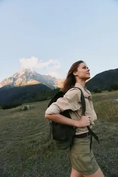 Активная женщина совершает поход в горы с рюкзаком, наслаждаясь свежим воздухом и приключениями на природе
