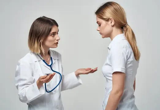 Женщина-врач с фонендоскопом объясняет пациентке диагноз