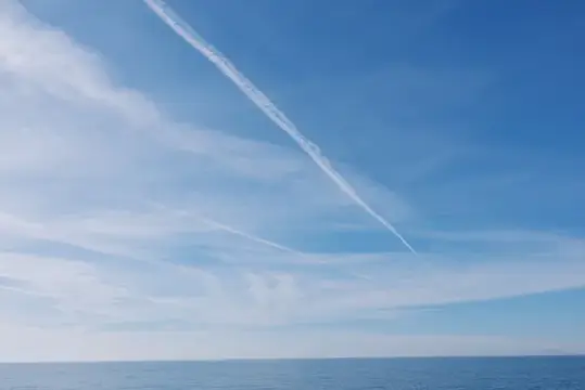 След самолёта в ясном небе над морем