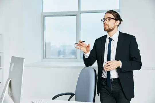 Офисный работник возле рабочего стола с офисным компьютером, руководитель