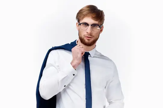 Портрет симпатичного блондина в классическом костюме и очках, с пиджаком на плече