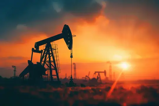 Нефтяные качалки вырисовываются силуэтами на фоне потрясающего заката, с глубокими оранжевыми и фиолетовыми тонами в небе, создавая захватывающий контраст с механизмами на переднем плане