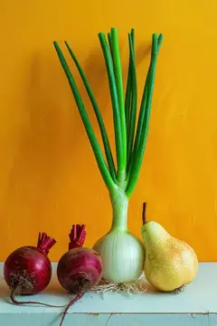Зелёный лук, красные луковицы и груша на фоне жёлтой стены
