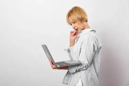 Блондинка с ноутбуком в офисе испытывает головную боль и стресс
