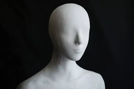 Гладкий, лишенный украшений белый манекен головы, установленный на темном фоне, подчеркивающий простоту, минимализм и художественное выражение в фэшн-фотографии и оформлении витрин