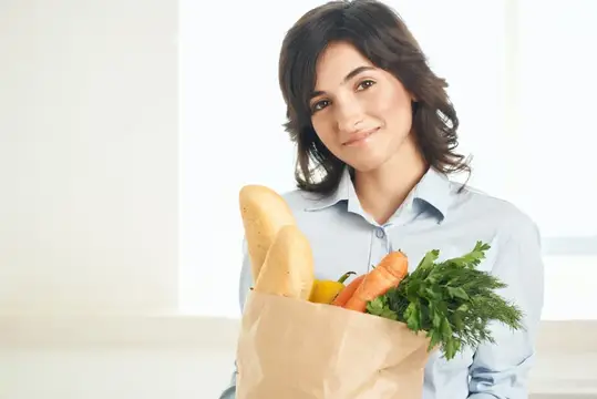 Весёлая женщина с пакетом продуктов, здоровая еда, овощи, домохозяйка