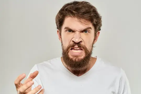 Мужчина в белой футболке выражает эмоции и жестикулирует руками