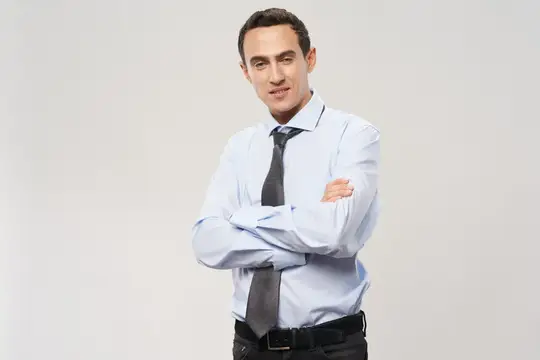 Деловой мужчина в классическом костюме скрестил руки на груди, кадрированный вид
