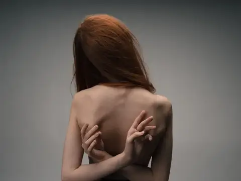 Женщина обнимает себя руками, вид со спины, обнаженная спина модели