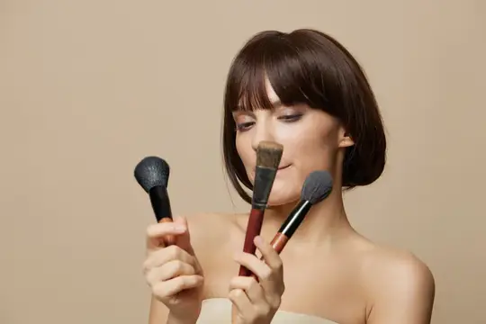 Молодая женщина улыбается, чистит зубы щеткой, короткая стрижка, крупный план
