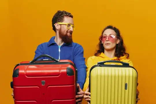 Мужчина и женщина с чемоданами на желтом фоне