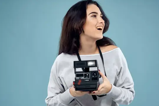 Женщина-фотограф с камерой на синем фоне