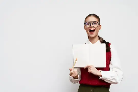 Удивлённая девушка в очках с блокнотом и карандашом
