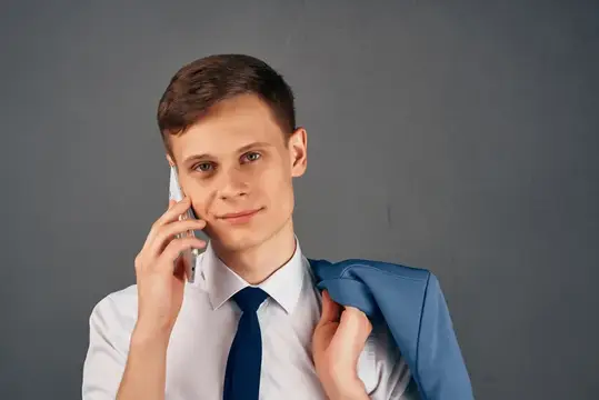Деловой мужчина в рубашке с галстуком разговаривает по телефону