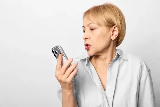 Светловолосая женщина говорит по телефону на белом фоне