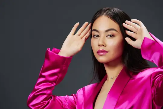 Красивая женщина в розовом мини-платье на роскошном сером фоне